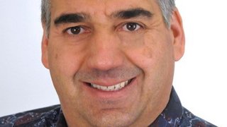 News Porträt eines lächelnden Mannes mit grauem Haar und gemustertem Hemd