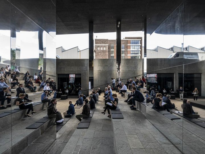 Collaborazioni & network Persone sedute in uno spazio moderno aperto con pareti a specchio