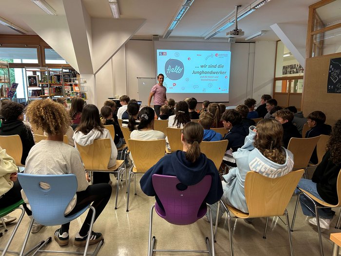 Entscheidung für den richtigen Beruf Jugendliche sitzen in einem Klassenzimmer und hören einem Vortrag zu
