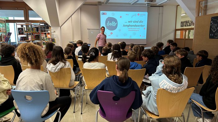 Entscheidung für den richtigen Beruf Jugendliche sitzen in einem Klassenzimmer und hören einem Vortrag zu