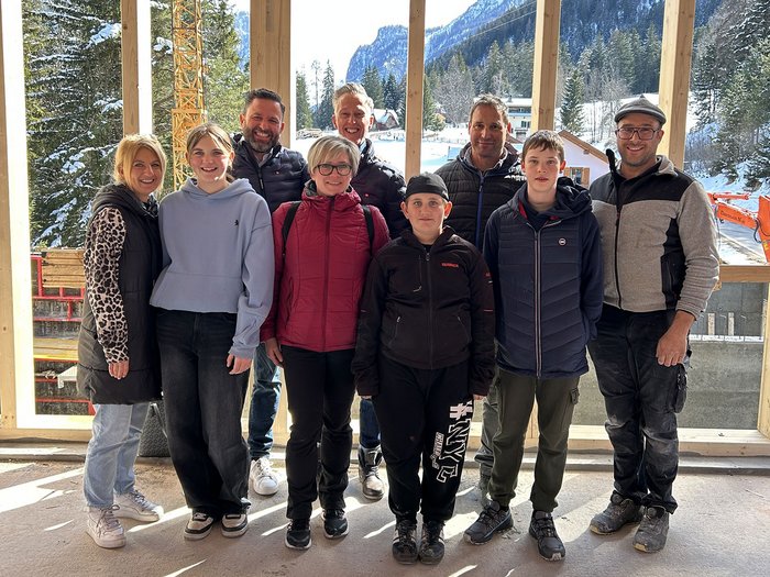 Handwerk zum Anfassen: SkillsDay begeistert im Oberpustertal Gruppe von neun Personen vor einem Holzrahmen mit verschneiten Bergen im Hintergrund