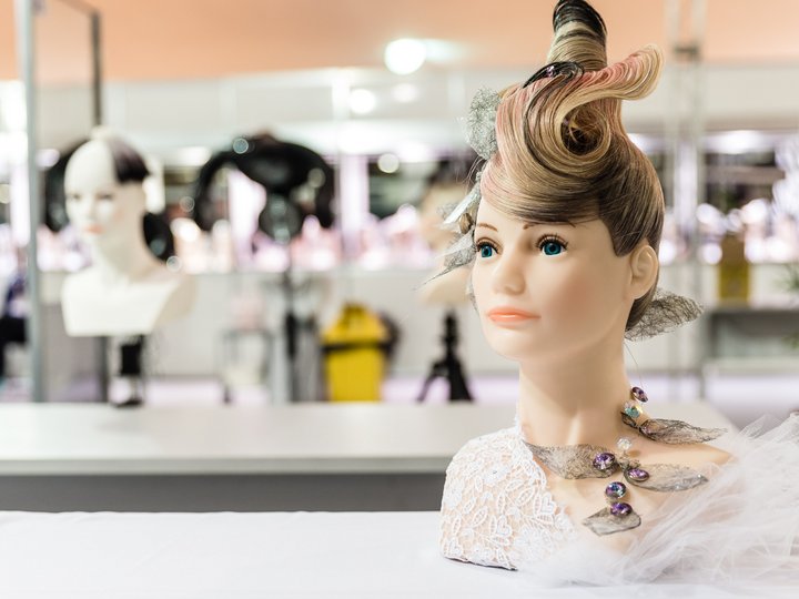 Friseure Schaufensterpuppe mit kunstvollem Haar und Schmuck auf weißem Tisch