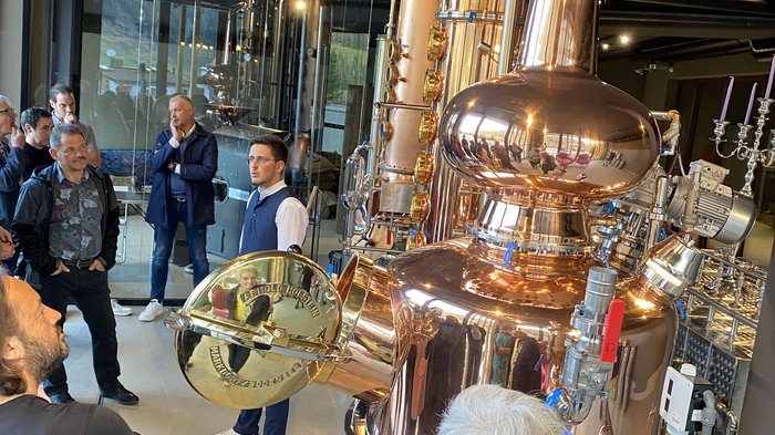 Tutti insieme: gli artigiani dell'Alta Val d'Isarco Visitatori in un tour di una distilleria con un grande alambicco in rame