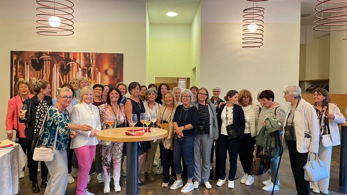 Frauenpower on Tour: Sommerausflug der „Frauen im Handwerk“ ins Fleimstal Große Gruppe Frauen bei Treffen in modernem Innenraum mit Getränken