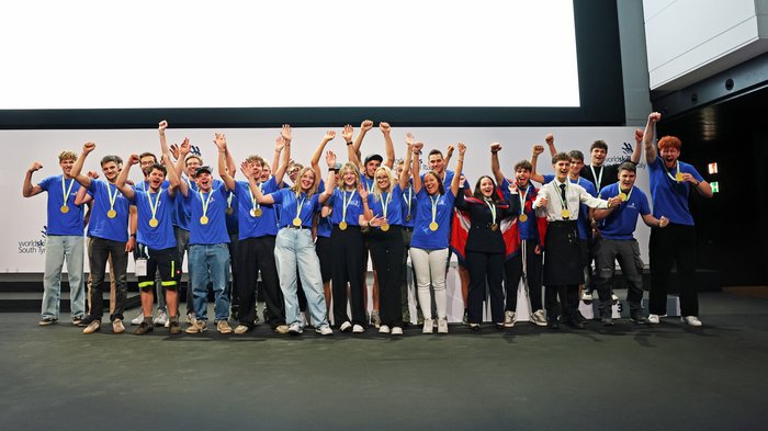 Cerimonia di chiusura dei WorldSkills South Tyrol, Italy: assegnati i riconoscimenti ai più meritevoli Giovani vincitori con medaglie esultano sul palco durante una premiazione