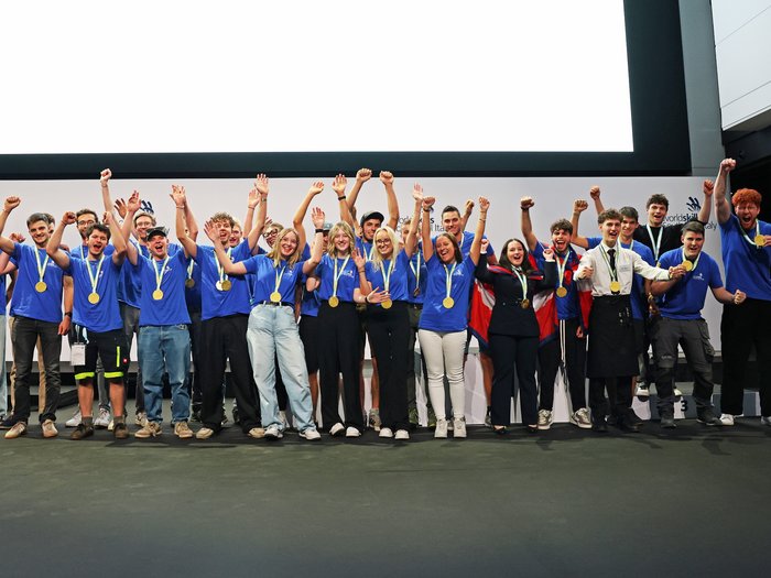 Cerimonia di chiusura dei WorldSkills South Tyrol, Italy: assegnati i riconoscimenti ai più meritevoli Giovani vincitori con medaglie esultano sul palco durante una premiazione