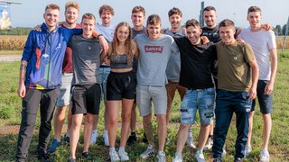 News Gruppe junger Menschen draußen stehen zusammen und lächeln auf einer Wiese