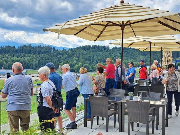 Viaggio culturale nel Burgenland – Opera e musical come fulcro del programma Gruppo di persone anziane guarda una pista da corsa sotto un cielo soleggiato