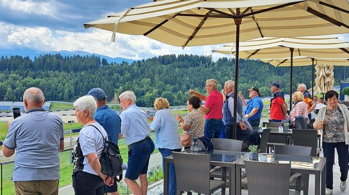 Viaggio culturale nel Burgenland – Opera e musical come fulcro del programma Gruppo di persone anziane guarda una pista da corsa sotto un cielo soleggiato