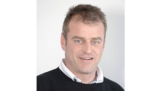 News Porträt eines lächelnden Mannes mit hellblauen Augen und braunem Haar