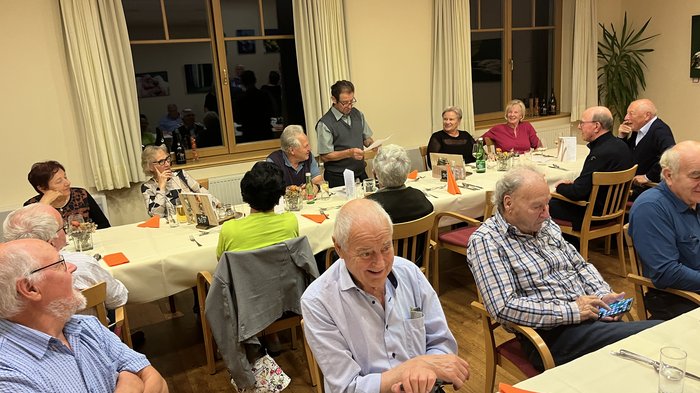 Althandwerker/innen unterwegs: Rundfahrt Weinviertel Gruppe älterer Menschen bei einer Versammlung an einem langen Tisch in einem Raum