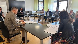 News Menschen sitzen an Tischen in einem Besprechungsraum bei einer Sitzung