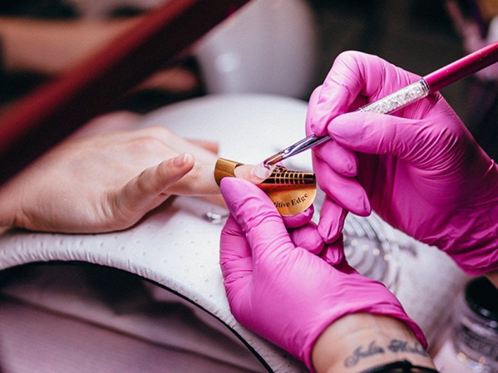 Perspektiven für Körperpflegeberufe Nageldesign mit Pinsel und Schablone bei Maniküre im Nagelstudio