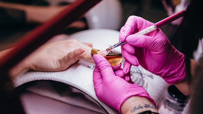 Perspektiven für Körperpflegeberufe Nageldesign mit Pinsel und Schablone bei Maniküre im Nagelstudio