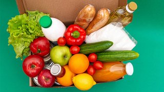 News Karton mit verschiedenen frischen Lebensmitteln wie Gemüse, Obst, Brot und Getränken