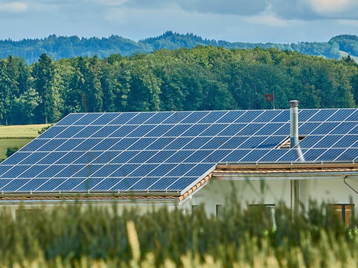 Energiespritze Superbonus Hausdach mit Solarpaneelen in ländlicher Umgebung