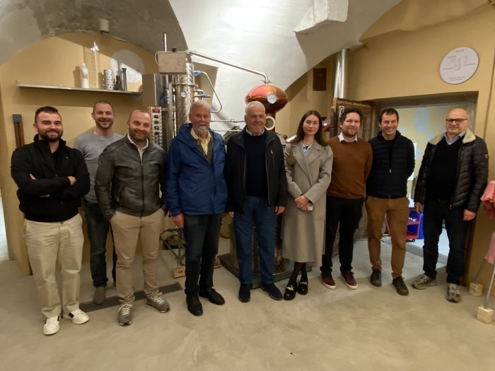 lvh-Ortsversammlung Bruneck: Ausblick auf vielversprechende Projekte und starke Zusammenarbeit Gruppe von zehn Personen steht in einem Raum mit Destillationsanlage im Hintergrund