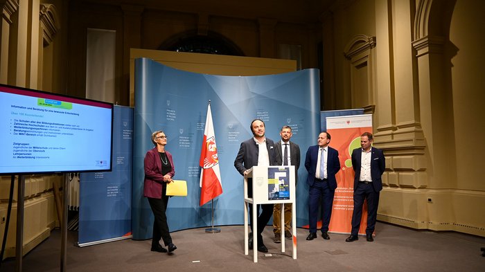 Futurum und World Skills Italy von 28. bis 30. September in Bozen Fünf Personen bei einer Pressekonferenz in einem Saal mit Flagge und Monitor