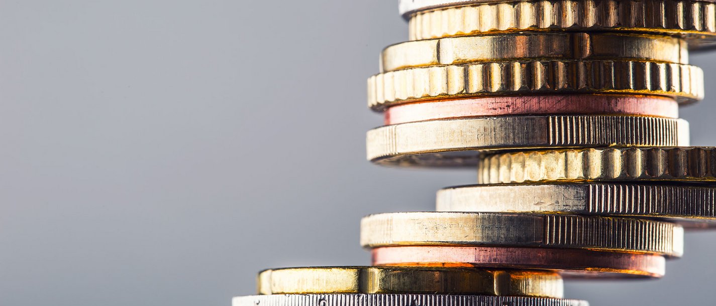 Öffentliche Förderungen und Nuova Sabatini Nahaufnahme eines Stapels Euro-Münzen vor grauem Hintergrund