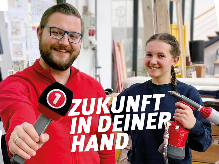 Lehrlingsaktion auf Südtirol 1: "Zukunft in deiner Hand" Mann mit Mikrofon und Frau mit Werkzeug lächeln in Werkstatt Zukunft in deiner Hand