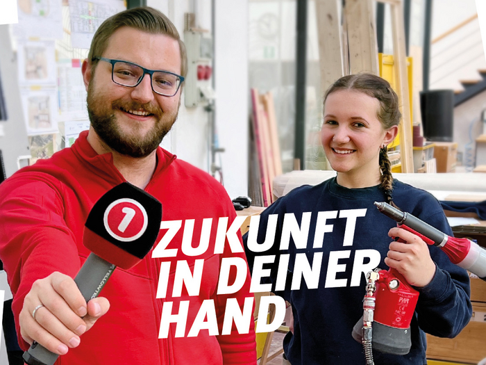 Iniziativa per apprendisti su Südtirol 1: “Il futuro nelle tue mani” Uomo con microfono e donna con attrezzo sorridono in officina Il futuro è nelle tue mani