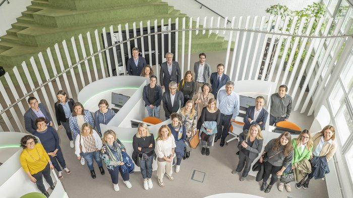 Südtiroler Delegation erkundete das Talentcenter in Graz Gruppenfoto von 27 Menschen in modernem Büro mit grünen Stufen und weißen Trennwänden