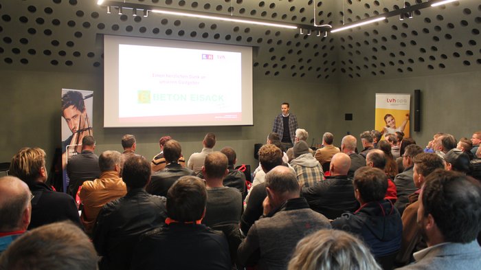 © lvh.apa Mann hält Vortrag vor Publikum in modernem Konferenzraum