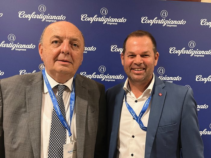 Hannes Mussak trifft italienischen Umweltminister Zwei Männer vor einer Confartigianato Imprese Fotowand bei einer Veranstaltung