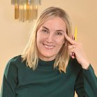 Das Nachhaltigkeitslabel Südtirol Lächelnde Frau mit Stiften über der Schulter in grünem Pullover