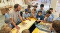 Kids-Academy 2024: Eine lehrreiche Erfahrung im Vinschgau Lehrer erklärt Kindern Handwerksarbeit in Werkstatt