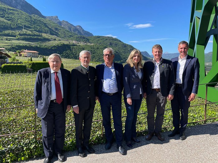 Mut und Miteinander entscheiden die Zukunft Sechs Personen posieren vor Berglandschaft und klarem Himmel