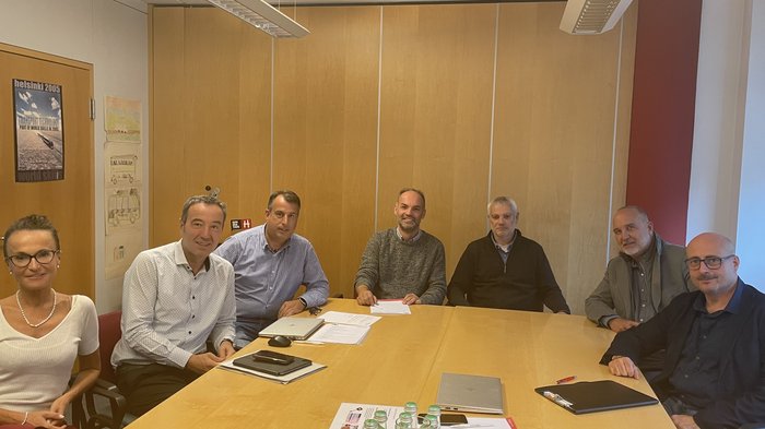 Südtiroler Transportbranche: mit vereinten Kräften unterwegs Sieben Personen in einem Meetingraum um einen Konferenztisch sitzend