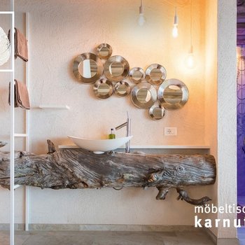 Möbeltischlerei Karnutsch Badezimmer mit Waschtisch aus Holzstamm und rundem Spiegel-Set an der Wand