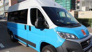 News Blauer und weißer Lieferwagen auf einer Stadtstraße