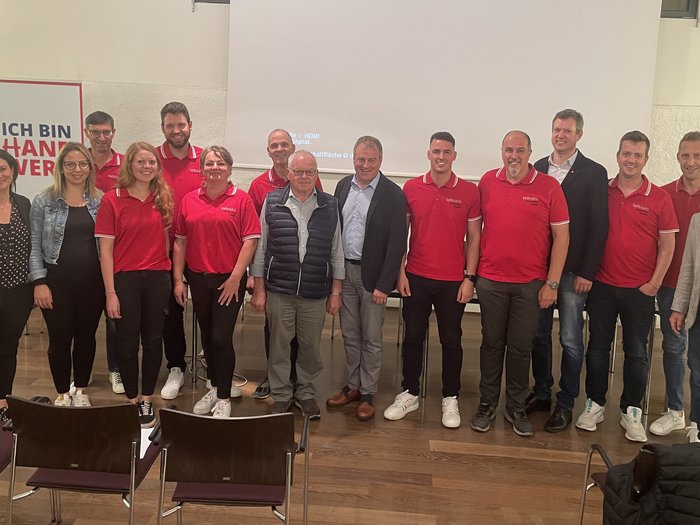 Successo dell'assemblea comunale di lvh.apa ad Appiano: focus su temi importanti per il futuro Foto di gruppo di 15 persone a un evento con abbigliamento rosso e business casual