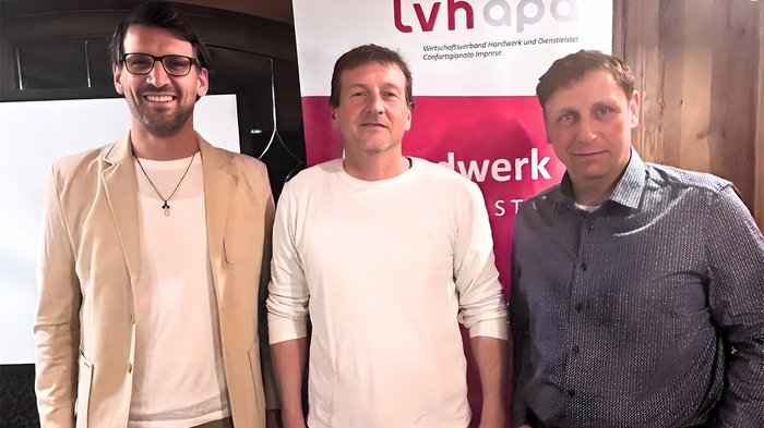 Ehrung und Beständigkeit beim Wengener Handwerk Drei Männer stehen vor lvhapa-Banner bei einer Veranstaltung