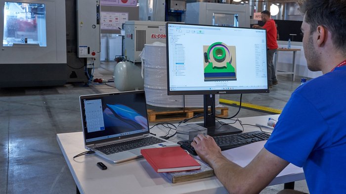 Freie Plätze Meisterkurs Maschinenbaumechaniker/in und Werkzeugmacher/in Mann arbeitet an CAD-Design auf PC in industrieller Produktionsumgebung