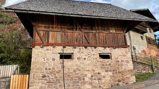 News Altes Gebäude mit steinernem Unterbau und hölzernem Oberteil an einer Straße