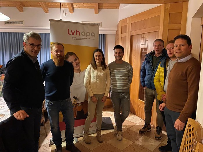 Ehrung und Beständigkeit beim Wengener Handwerk Sieben Personen stehen vor einem LVH APA Banner in einem Raum mit Holztüren