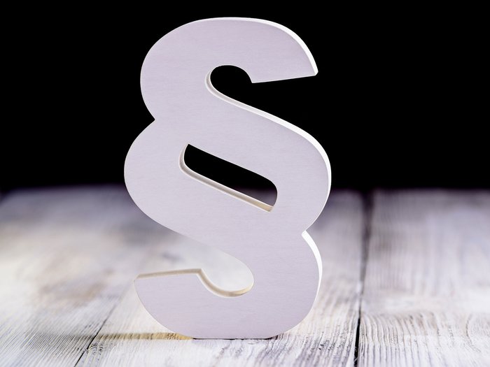 SOA: un carico ulteriore per le aziende Simbolo del paragrafo bianco su pavimento in legno con sfondo nero