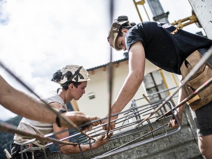L’esempio virtuoso dell’artigianato edile altoatesino Operai edili al lavoro con struttura in metallo su un cantiere all'aperto