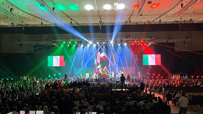 EuroSkills 2023 al nastro di partenza! Conferenza con bandiere italiane e luci colorate sul palco davanti a grande folla