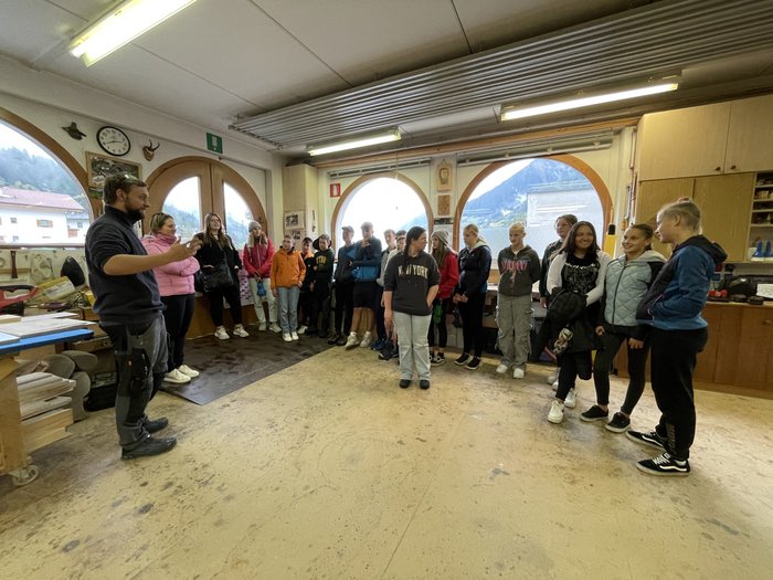 Campagna informazione carriere San Leonardo in Passiria Gruppo di giovani in un laboratorio che ascoltano un uomo che parla