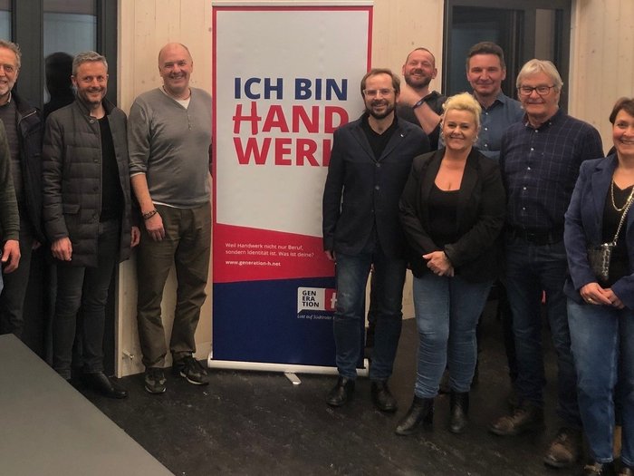 Zukunft gestalten, Handwerk stärken: lvh-Ortsversammlung in Vahrn Gruppe von Leuten steht vor einem Banner mit Schrift ICH BIN HANDWERK
