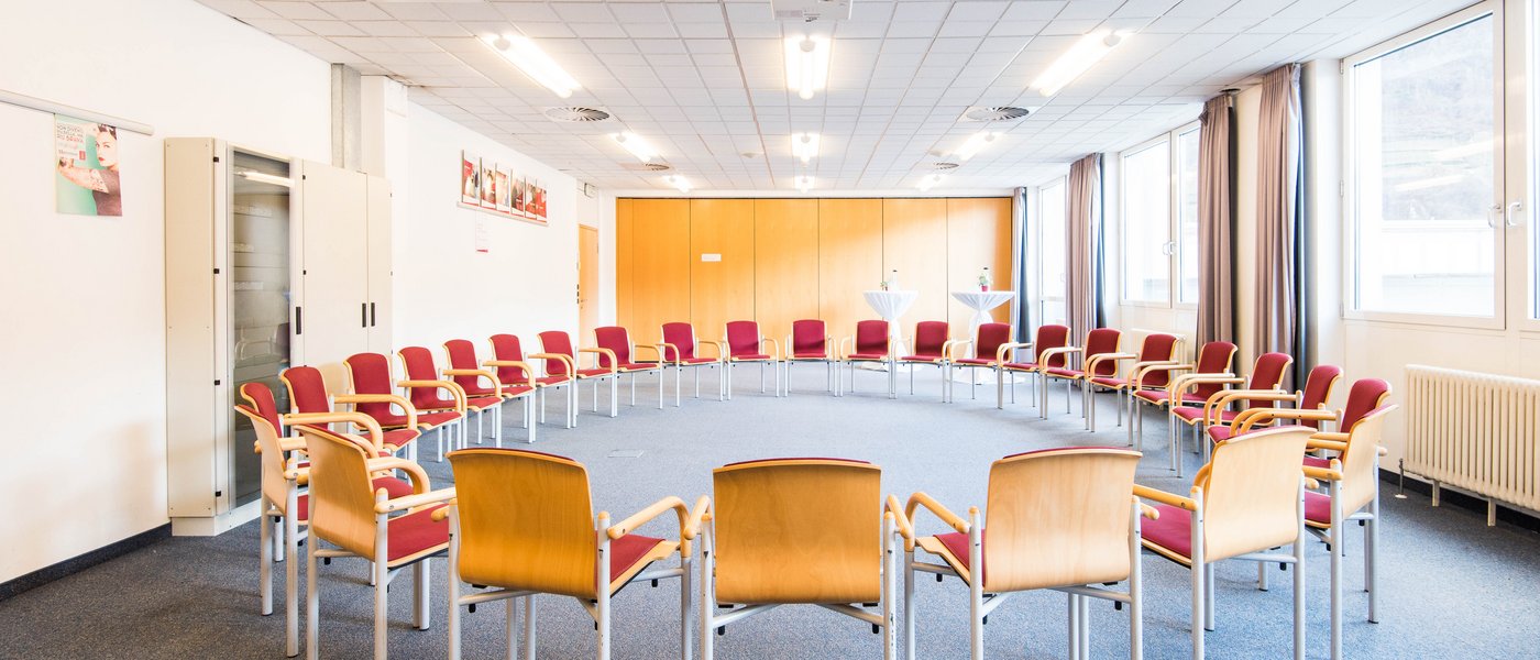 Affitto aule seminari Sala conferenze vuota con sedie disposte a cerchio e proiettore sul soffitto