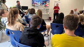 News Vortrag über Handwerksberufe vor Jugendlichen in einem Klassenraum