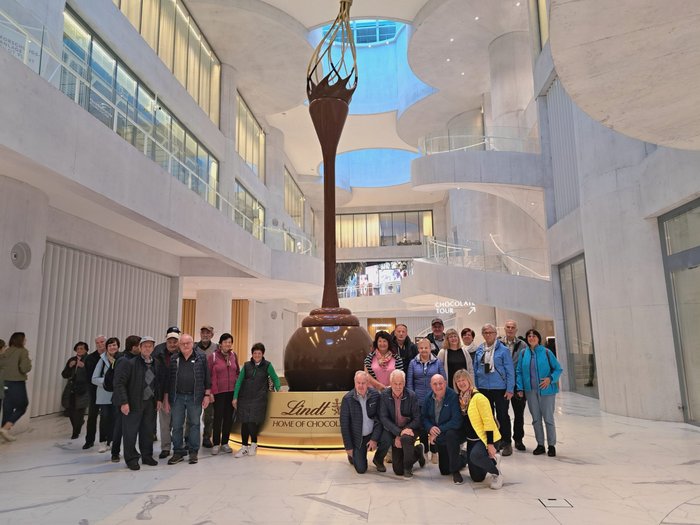 Herbstreise der Althandwerker/innen im lvh: Schweizer Genuss und Panorama pur Gruppe vor großer Lindt Schokoladen-Skulptur in modernem Gebäude