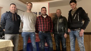 News Fünf Männer stehen in Innenraum vor einem Werbebanner