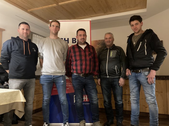 Neuer lvh-Ortsobmann in Mühlwald Fünf Männer stehen in Innenraum vor einem Werbebanner