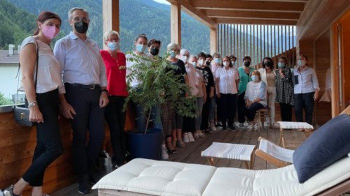 Frauen am Ruder Gruppe von Menschen mit Masken auf einer überdachten Terrasse in den Bergen
